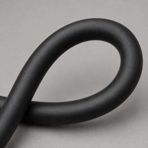 Close-up of flexible black rubber sheath on welding cable bent in a loop