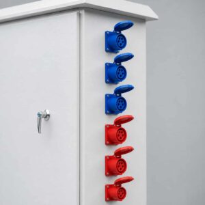 Close-up of color-coded industrial round sockets on site distribution box side panel
