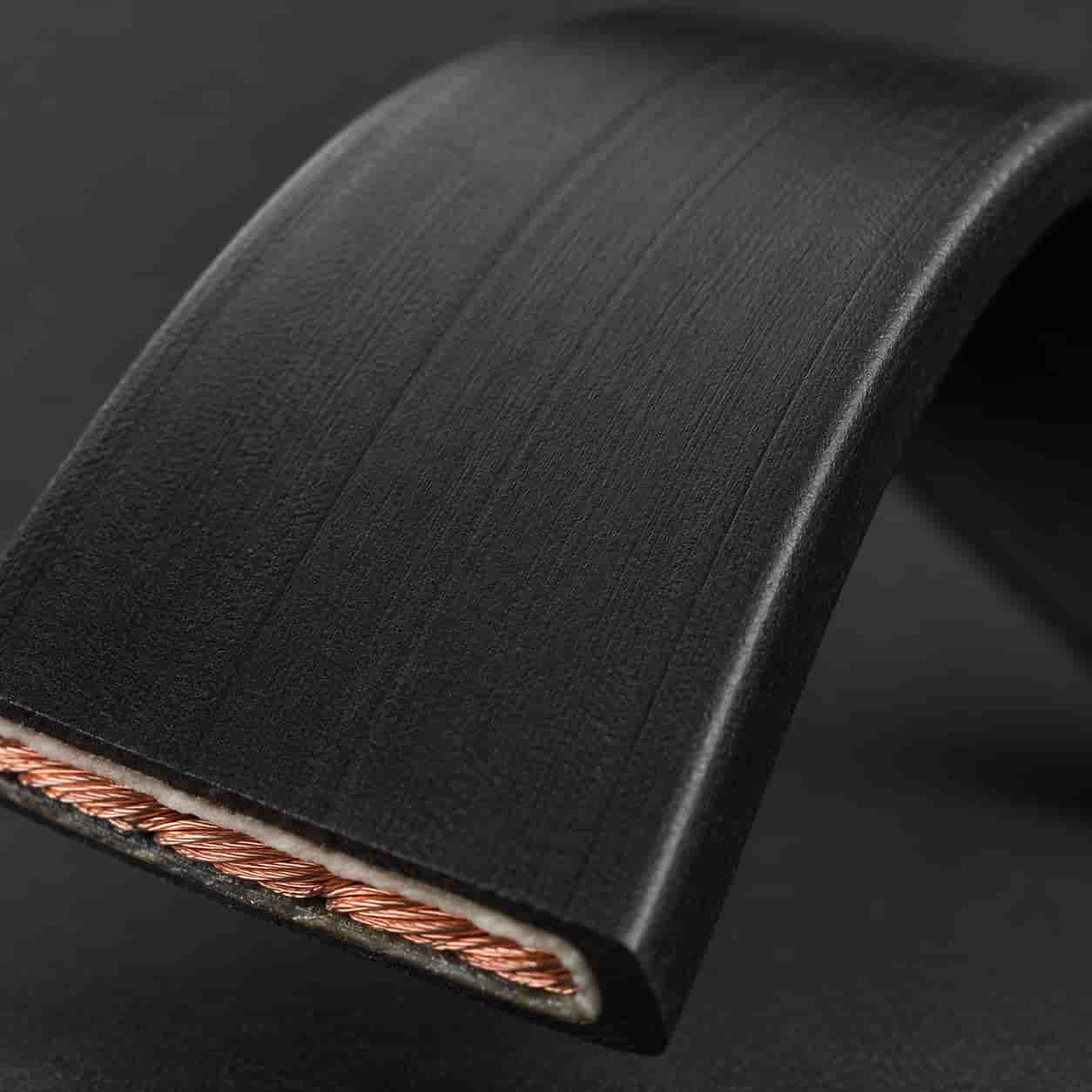 Close-up of flat composite cable surface showing flat ribbon profile and sheath texture